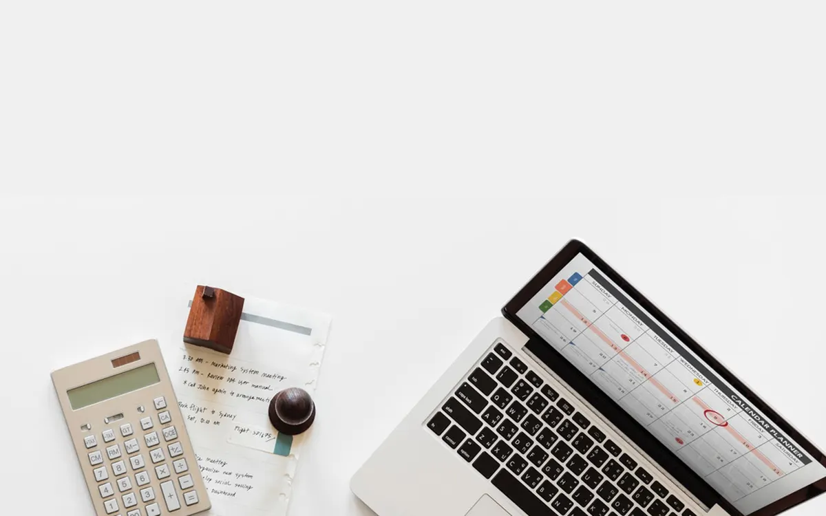 Desk with a laptop, a calculator and documents