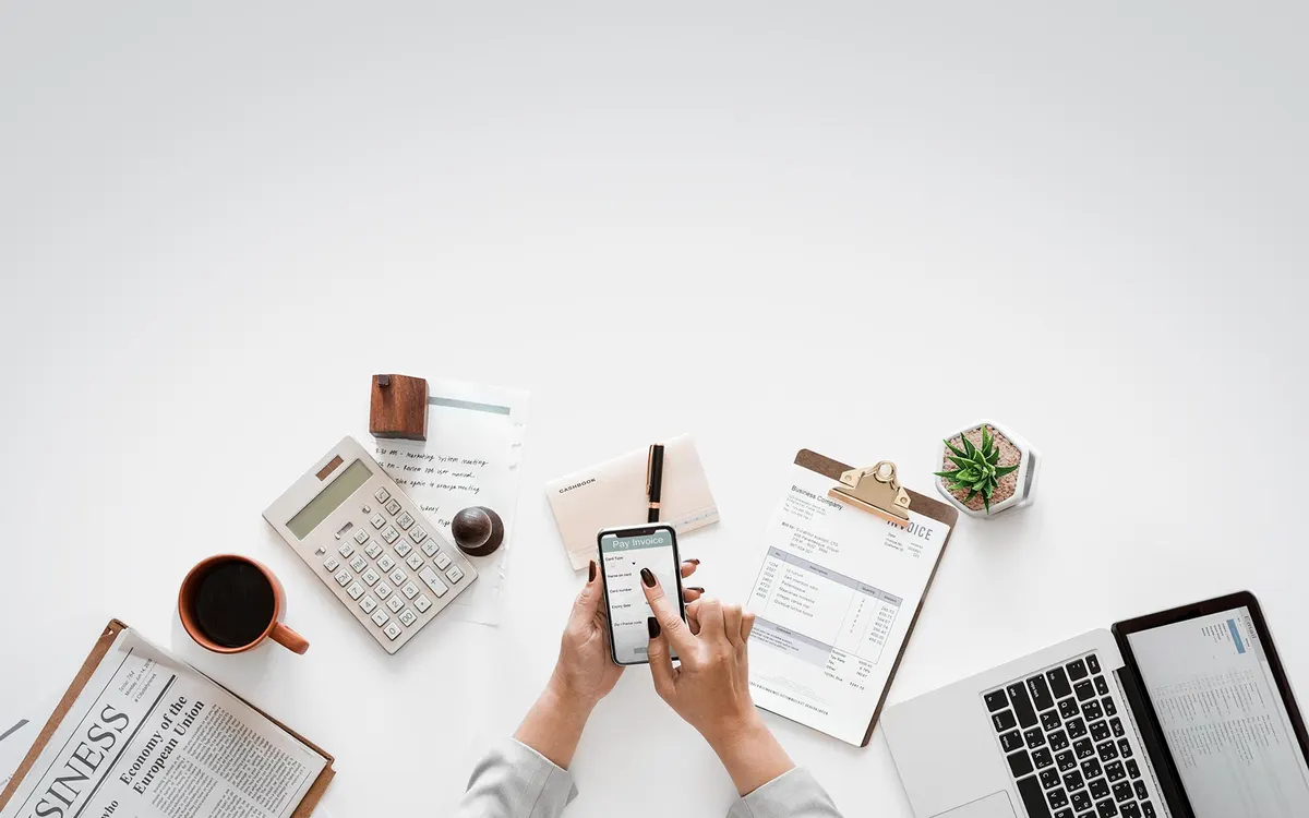 Desk with a calculator, documents and a laptop