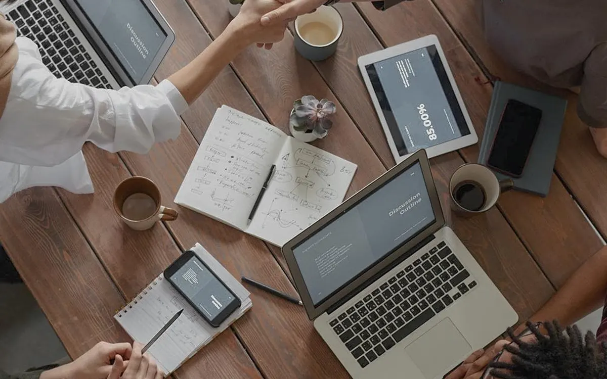 A team with laptops and documents at a work table